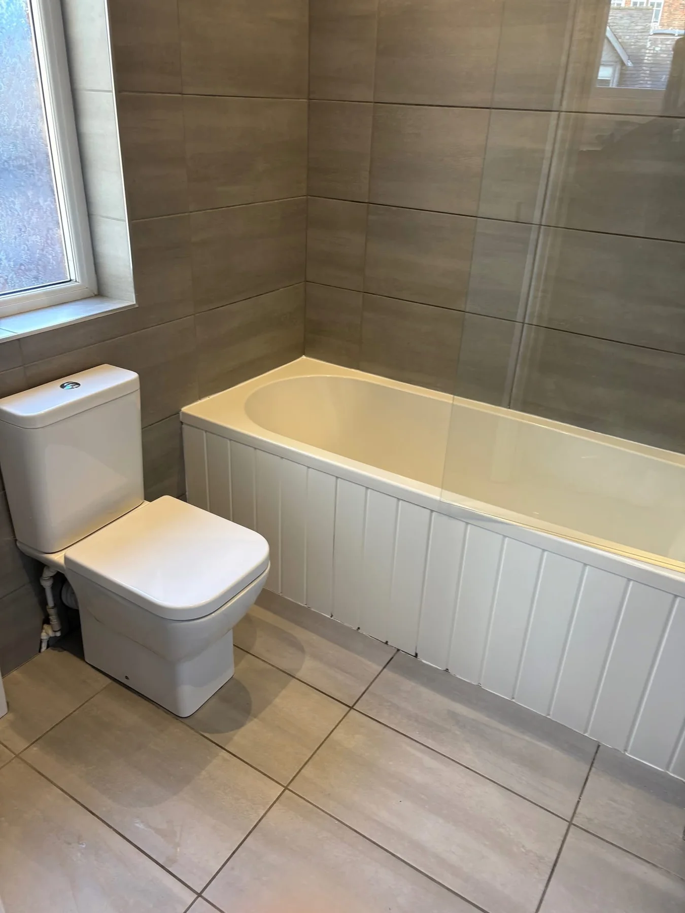 Clean bath, toilet and tiled bathroom floor