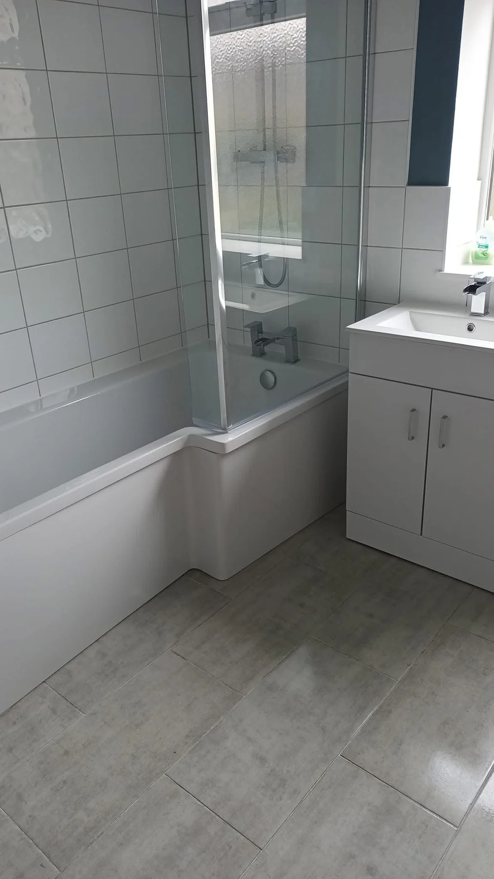 Clean bath, shower screen and white basin cabinet