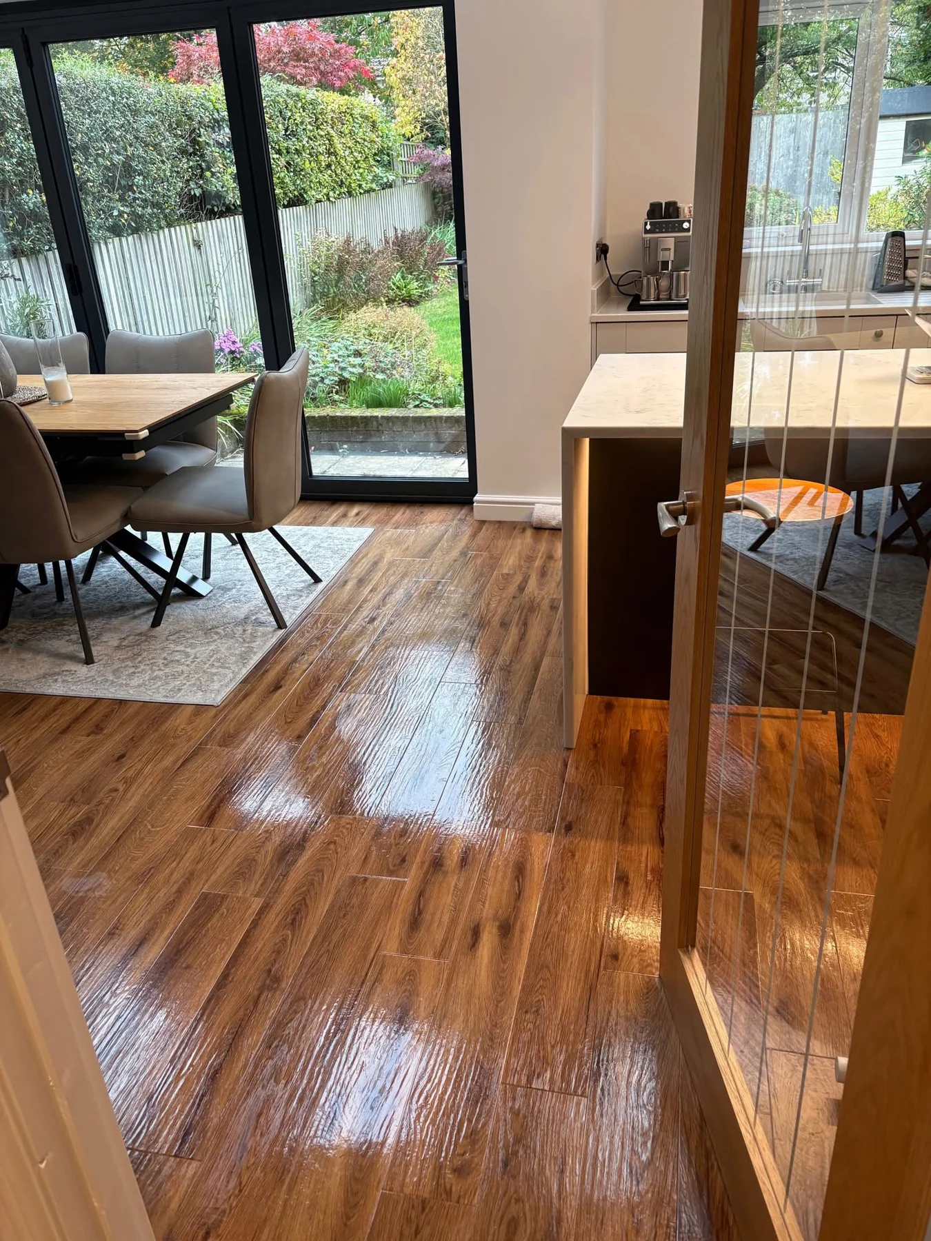 Clean wood-effect flooring leading to a dining space